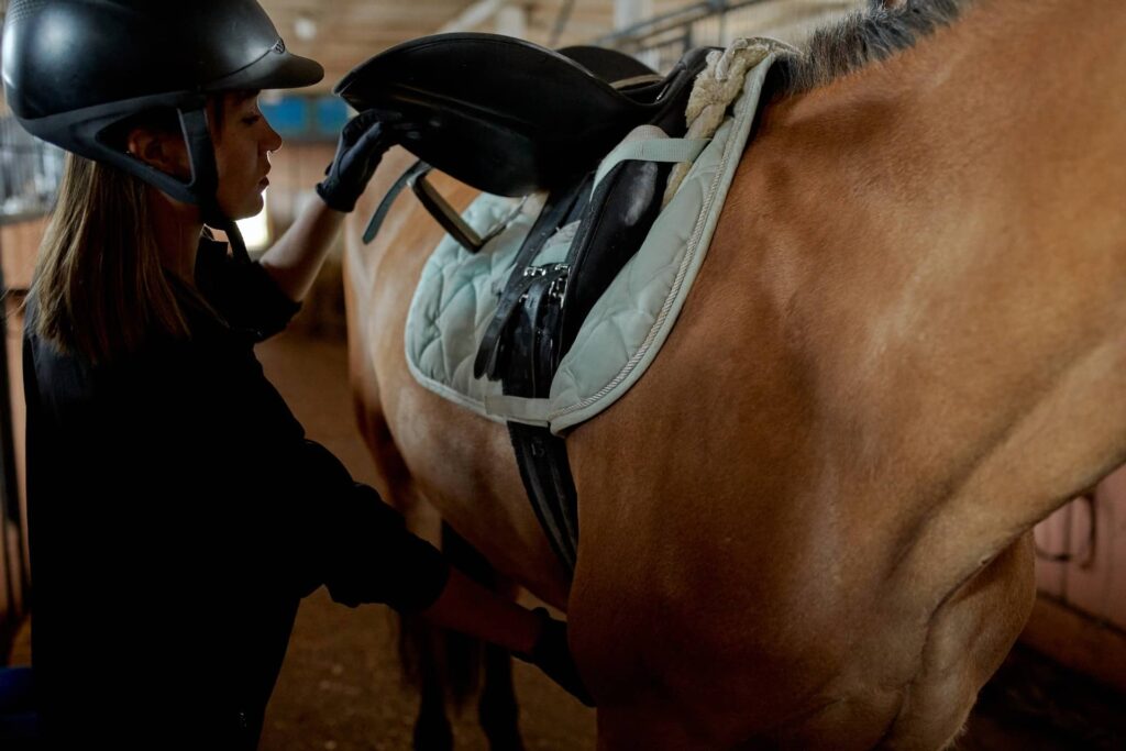 Beginner horse rider checking saddle